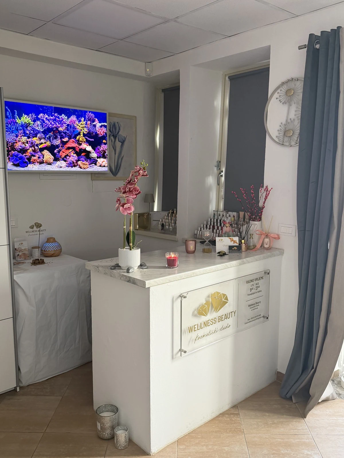 Recepcija Wellness Beauty studija s mramornim pultom i logotipom Emili Kenda